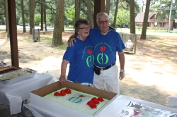 Couple standing by cake